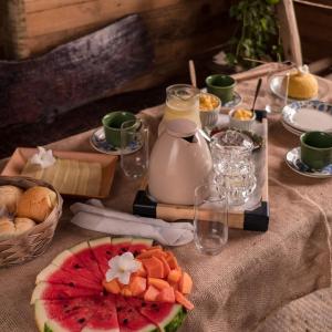 卡馬薩里的住宿－Flor da Aldeia Eco Hospedaria，一张桌子,上面放着水果和奶酪,还有一壶牛奶