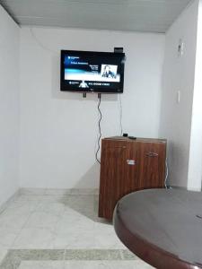 ビリャビセンシオにあるHermoso apartamento independiente para parejaの壁に薄型テレビが備わる客室です。