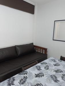 - un canapé noir dans une chambre avec un lit dans l'établissement DPTO VICTORIA IV, à Mar del Plata