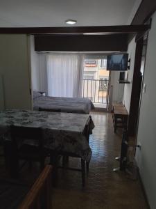 Cette chambre comprend deux lits, une télévision et une table. dans l'établissement DPTO VICTORIA IV, à Mar del Plata