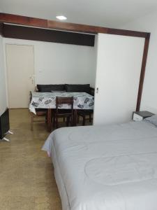 1 dormitorio con 1 cama, mesa y sillas en DPTO VICTORIA IV en Mar del Plata