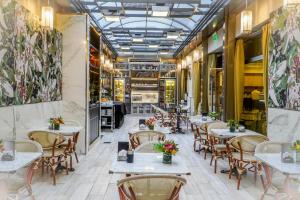 - un restaurant avec des tables et des chaises dans une salle dans l'établissement Konke Buenos Aires Hotel, à Buenos Aires