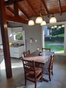 una cucina e una sala da pranzo con tavolo e sedie di Cabañas Antares a Mar de las Pampas