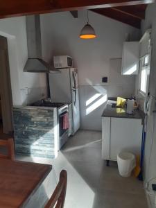 a small kitchen with a stove and a refrigerator at Cabañas Antares in Mar de las Pampas