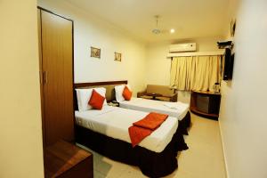 a hotel room with two beds and a television at Sitara Paradise in Hyderabad