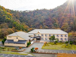 une vue aérienne sur un bâtiment avec des montagnes en arrière-plan dans l'établissement The Gran Resort Kinosaki, à Toyooka