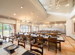une grande salle à manger avec des tables et des chaises dans l'établissement The Gran Resort Kinosaki, à Toyooka