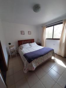 sypialnia z łóżkiem i dużym oknem w obiekcie Cabaña entre Nogales w mieście Horcon