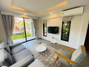 a living room with a couch and a tv at The Retreat Ao nang Private Pool Villa in Ao Nang Beach