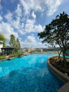 uma grande piscina com água azul e uma árvore em 10pax walk 4min to MRT near Axiata Bukit jalil & Pavilion2 em Seri Kembangan