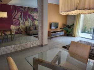sala de estar con sofá y TV en New 3 bedroom home in modern housing complex, en Manta