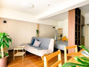 a living room with a couch and a bed at Home n Lounge in Tokyo