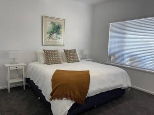 a bedroom with a large bed with a blanket on it at Middleton Views Villa in Albany