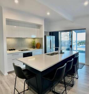 a kitchen with a large island with chairs in it at Middleton Views Villa in Albany