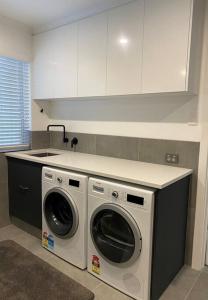 a kitchen with a washing machine and a sink at Middleton Views Villa in Albany