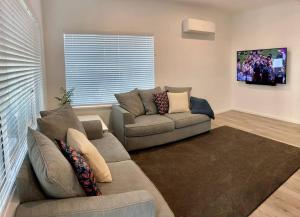 a living room with a couch and a large window at Middleton Views Villa in Albany