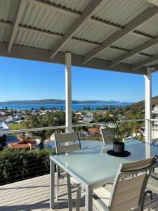 - une table et des chaises sur une terrasse couverte offrant une vue sur l'océan dans l'établissement Middleton Views Villa, à Albany