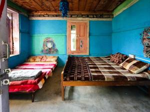 2 camas en una habitación con paredes azules en Gypsy House, en Kalgha