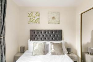 1 dormitorio con 1 cama con sábanas y almohadas blancas en The Summit Apartment Aberdeen City Central Perfect Short or long stay en Aberdeen