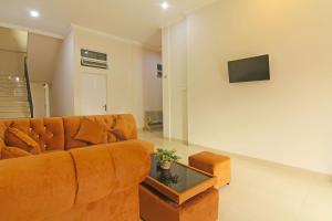 uma sala de estar com um sofá castanho e uma mesa em Capital O 91675 Utama Residence em Padang