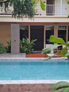 a swimming pool in front of a house at Feung Nakorn Balcony Rooms and Cafe in Bangkok