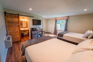 a hotel room with two beds and a kitchen at Evergreen Motel in Libby