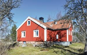 una casa roja en la cima de una colina con árboles en 2 Bedroom Nice Home In Lnashult en Lönashult