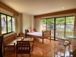 a bedroom with a bed and a table and chairs at Kata View Guest House in Kata Beach