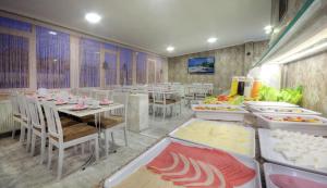 a restaurant with tables and chairs with food on them at Hotel Abro Sezenler in Ankara