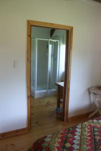 a mirror in a room with a bedroom at Fijnbosch Cottage and Camping in Stormsrivier