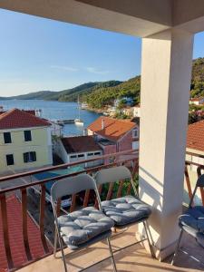 een balkon met 2 stoelen en uitzicht op het water bij Apartment Silvana - 100 m from beach in Božava