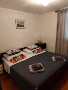 a bedroom with two beds with towels on them at Apartment Silvana-100m from beach in Božava