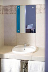 een badkamer met een wastafel, een spiegel en handdoeken bij 1001 Nights Boutique Inn in Cagayan de Oro