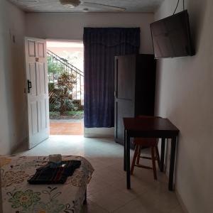 a room with a bed and a table and a desk at ECONOMIQUE in Jacó