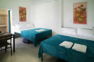 a room with two beds and a table and a desk at 1001 Nights Boutique Inn in Cagayan de Oro