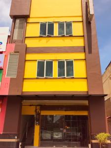 a yellow building with windows on a street at Intanova Hotel in Teluk Intan