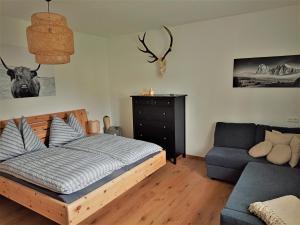 a bedroom with a bed and a blue couch at Family Home Weißensee in Greifenburg