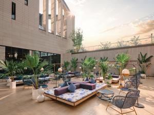 een lobby van een gebouw met een bank en stoelen bij Hotel Indigo Hangzhou Uptown,Close to Westlake , boutique design hotel with freeflow minibar in Hangzhou