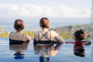 eine Gruppe von drei Frauen, die in einem Schwimmbad sitzen in der Unterkunft KiBata Lembongan Boutique Hotel in Nusa Lembongan