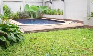 a small swimming pool in a yard with grass at Kemang Utara Creative Villas in Jakarta