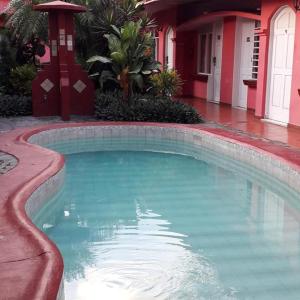 a swimming pool in front of a house at ECONOMIQUE in Jacó