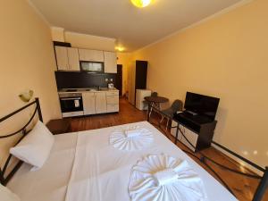 Habitación con cama blanca y cocina en MitProt Panorama Bay 2 ap 30, en Sveti Vlas