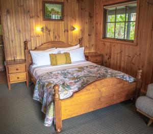 a bedroom with a bed in a wooden room at Gaol House Cottages in Bicheno