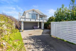 a house with a balcony on top of a garage at Campbell Road Classic - Mount Maunganui Bach in Mount Maunganui