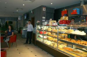 a man standing in front of a bakery display case at Cetin Hotel in Kesan