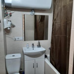 a bathroom with a sink and a toilet and a mirror at Отдельная Квартира со всеми удобствами in Chişinău