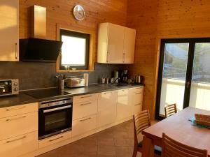 a kitchen with white cabinets and a table with a dining room at EifelGlückV in Rieden