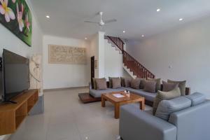 a living room with a couch and a tv at Villa Verano at Echo Beach Canggu in Canggu