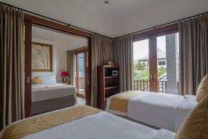 ein Hotelzimmer mit zwei Betten und Balkon in der Unterkunft Villa Verano at Echo Beach Canggu in Canggu + 16 Fotos