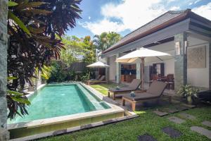 a backyard with a swimming pool and a house at Villa Verano at Echo Beach Canggu in Canggu